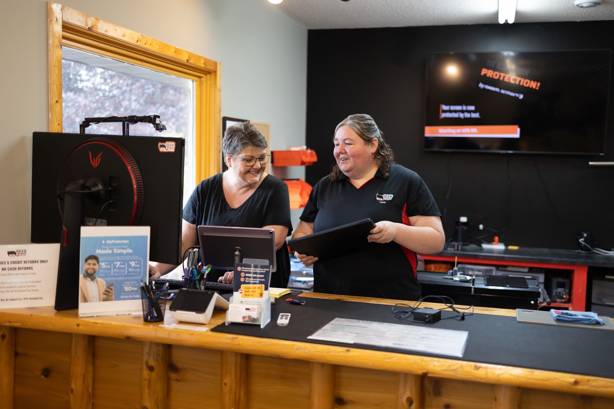Geek2Go staff helping a customer at the Pequot Lakes repair counter
