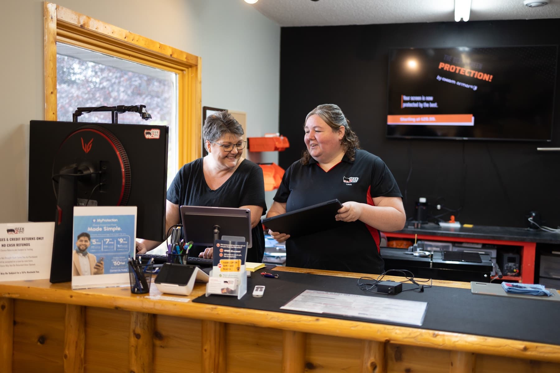 Geek2Go staff reviewing repair options at the counter