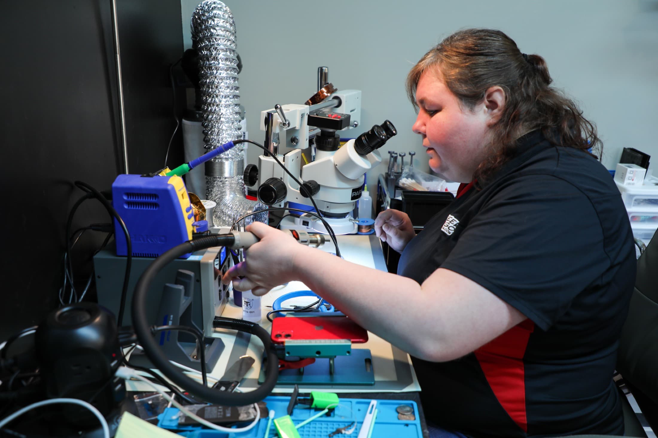 Geek2Go technician working at a microsoldering repair bench